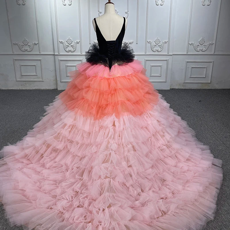 Pink and black quinceanera dress with layered organza ruffles and deep V-neck bodice, showcasing an elegant evening ball gown.