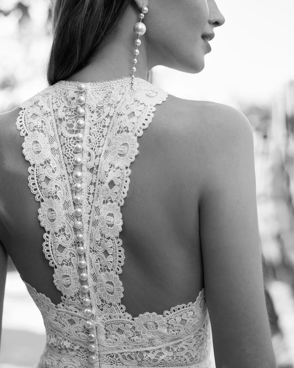 Woman wearing a bridal white lace halter top and wide-leg pants on a white background wedding jumpsuit