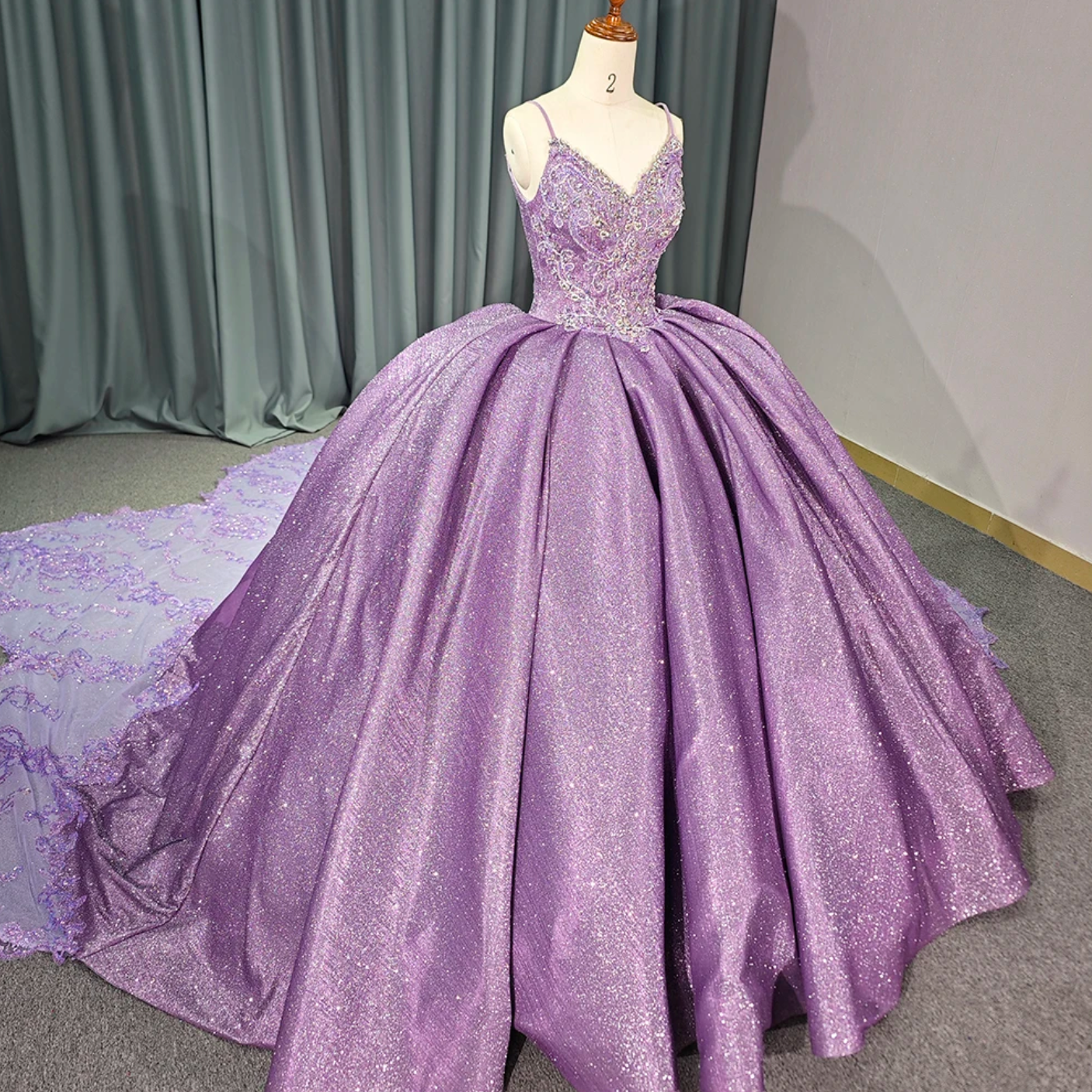 Purple shiny princess quinceanera dress with voluminous skirt and intricate beaded lace bodice.