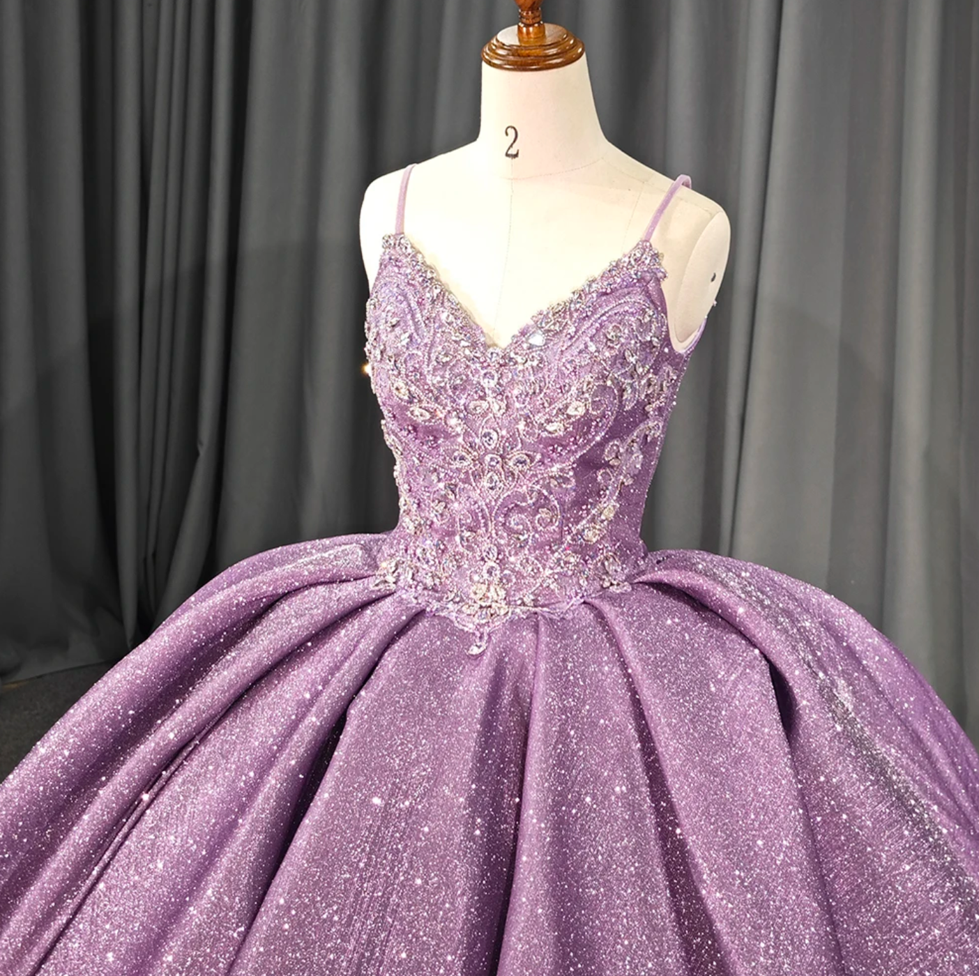 Purple shiny quinceanera dress featuring a beaded lace bodice and voluminous princess-style skirt.