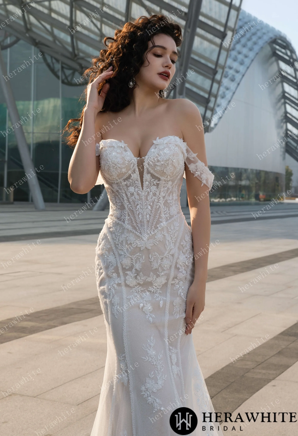 Elegant off the shoulder wedding dress with detachable train and intricate lace details, showcasing a fit and flare silhouette.