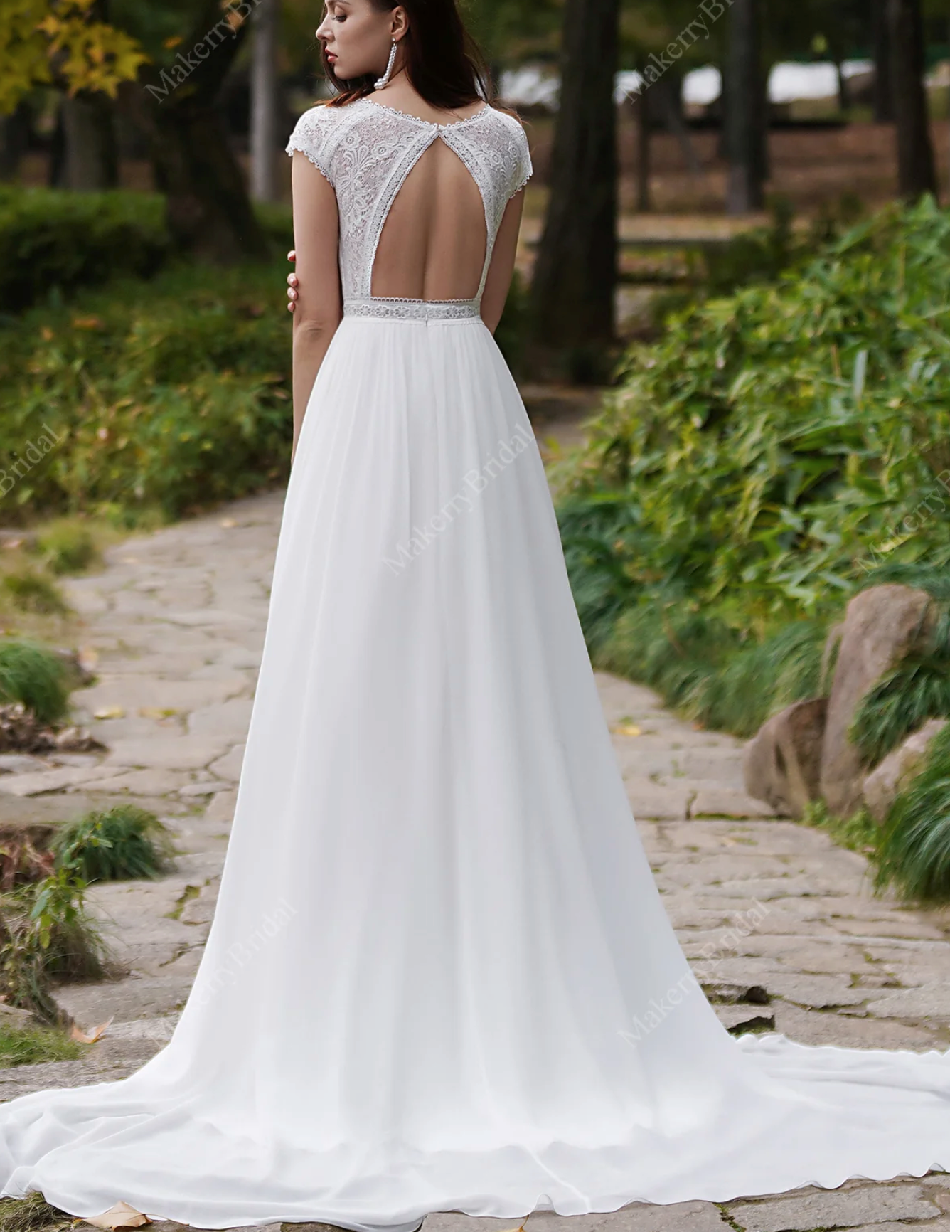 Elegant chiffon bohemian wedding dress with cap sleeves and open back, displayed in ivory with a long train.
