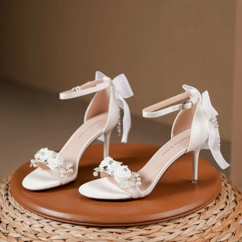 wedding bridal shoes open toe with floral accents on the toe bridge with a ankle strap and heel bow with pearl beading and heels.