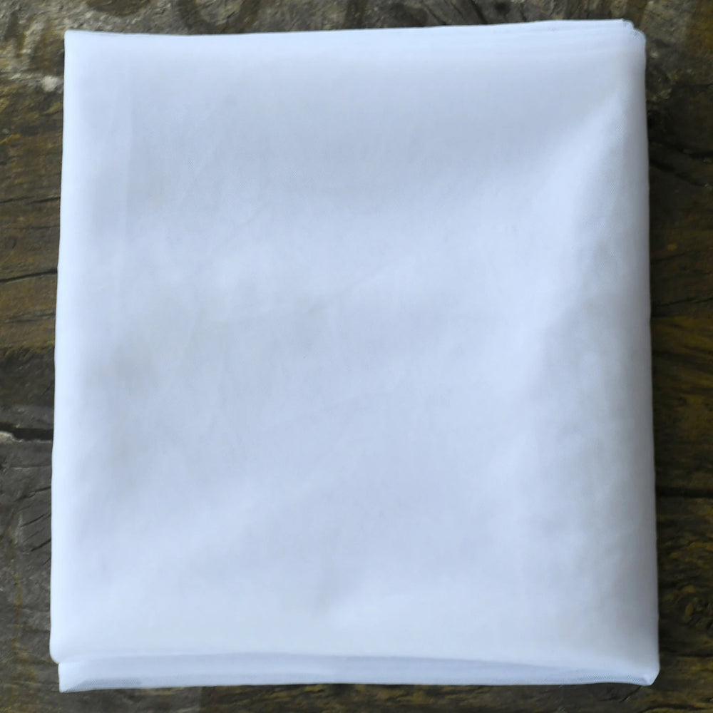 
                      
                        Folded white fabric on a wooden surface
                      
                    