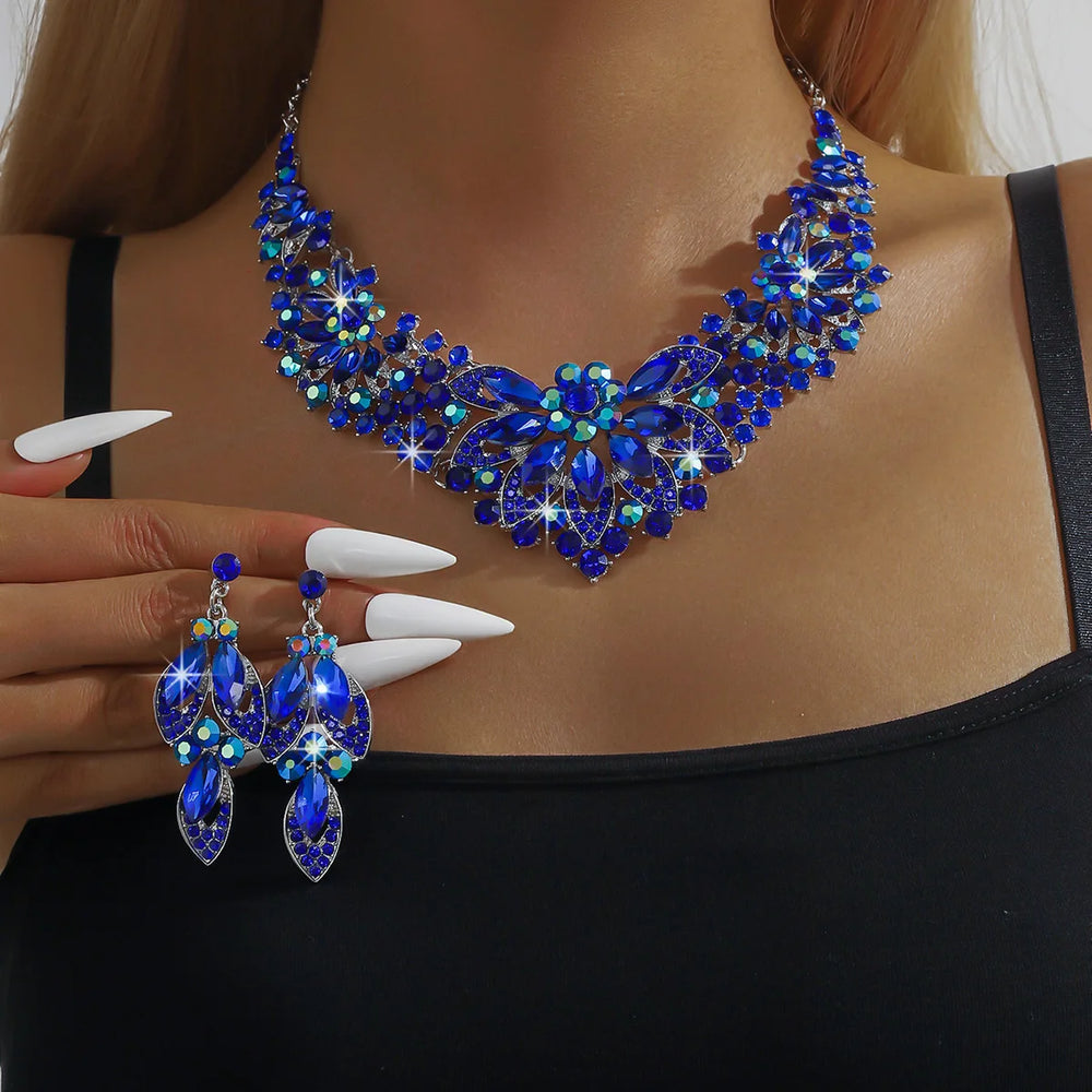 Blue gemstone necklace and earrings on a model with a plain background