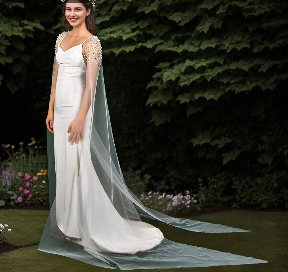 
                      
                        Woman in a white wedding dress with a long veil standing outdoors.
                      
                    