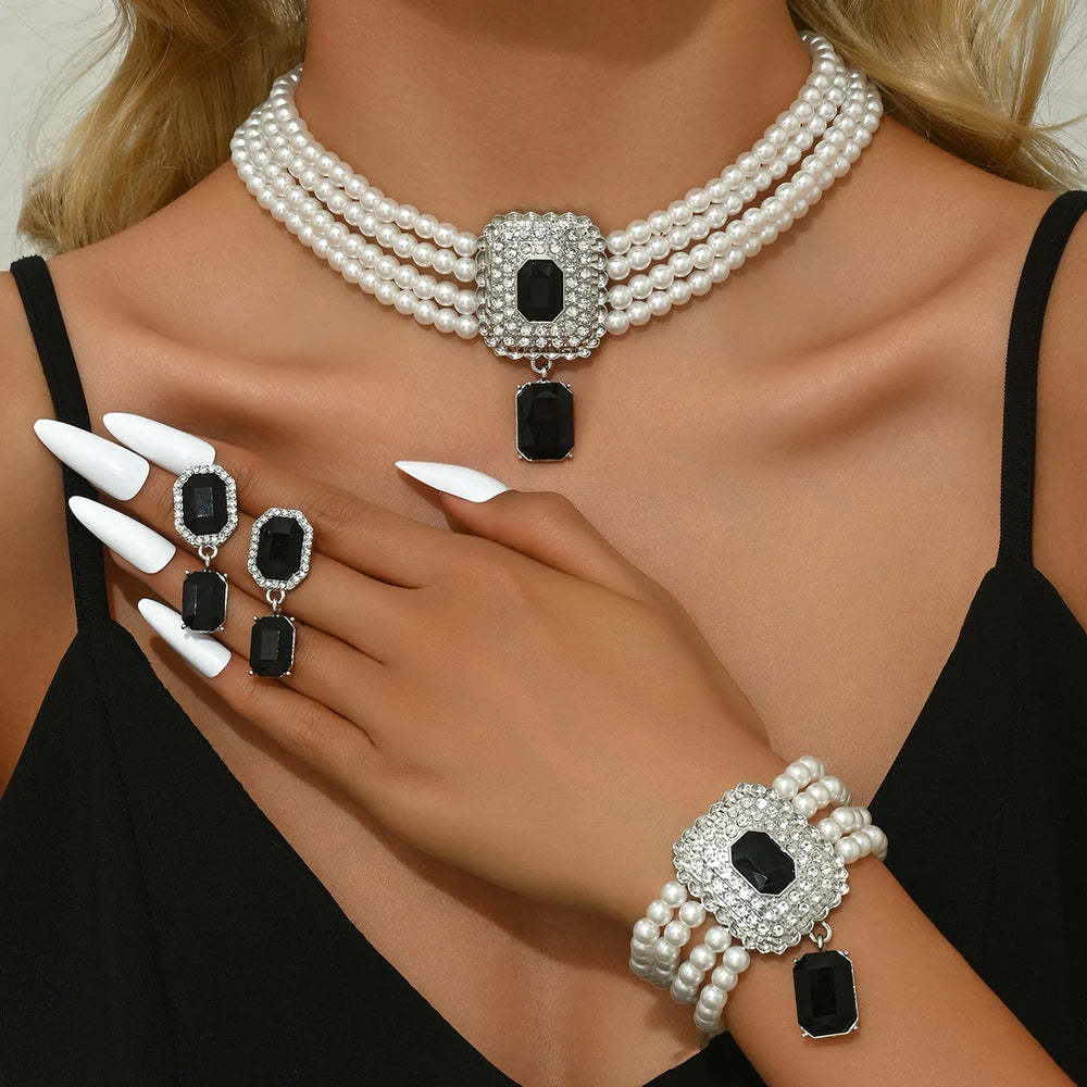 
                      
                        Pearl necklace, earrings, and bracelet set on a model with black stones
                      
                    