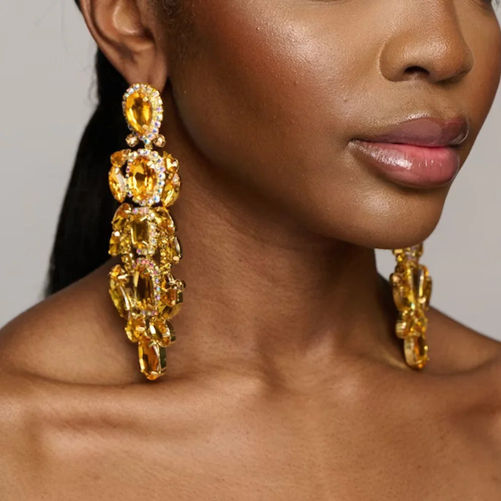 
                      
                        Close-up of a woman wearing gold earrings with a neutral background
                      
                    