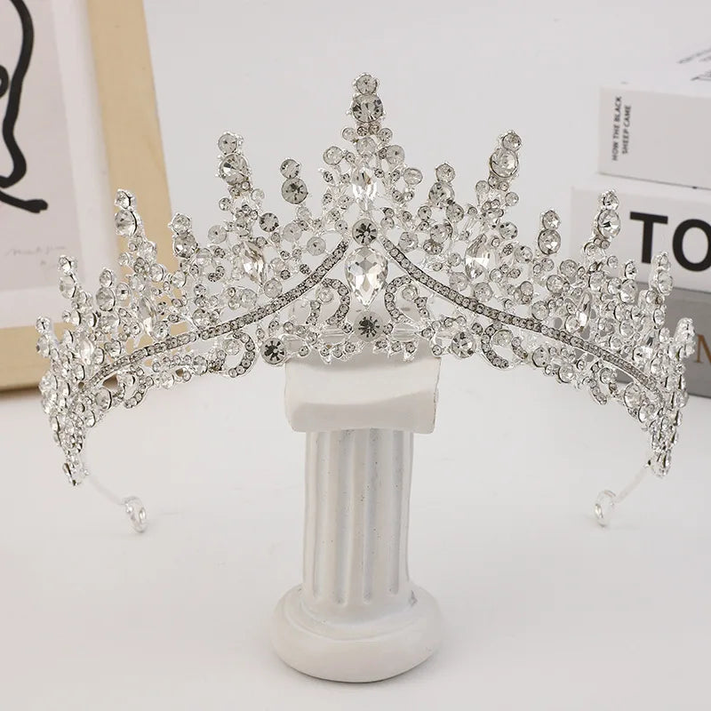 
                      
                        Silver tiara with crystals on a white pedestal against a light background
                      
                    