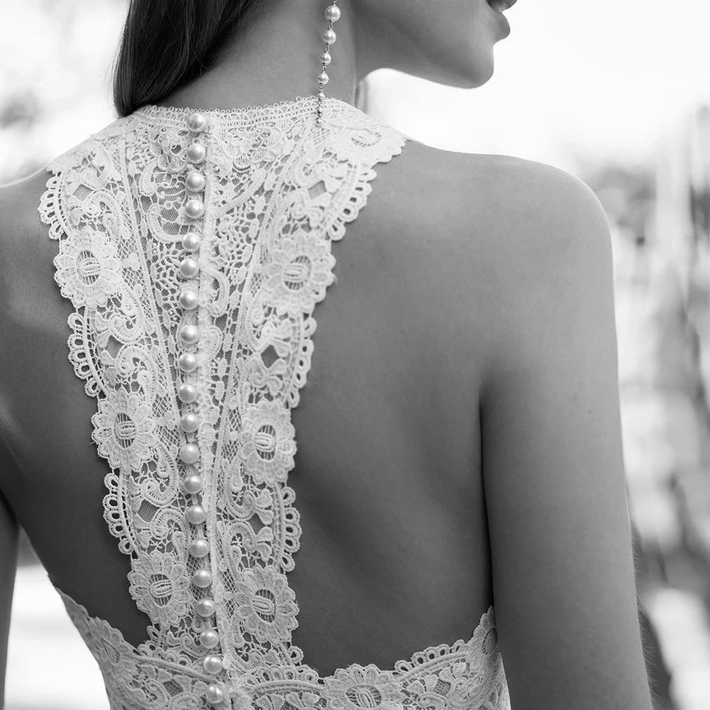 
                      
                        Woman wearing a bridal white lace halter top and wide-leg pants on a white background wedding jumpsuit
                      
                    