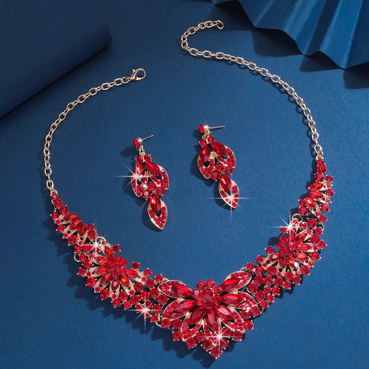Red jewelry set with necklace and earrings on a blue background