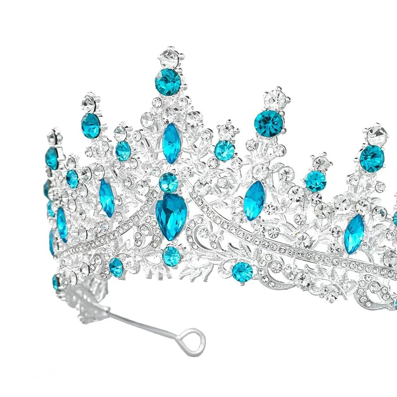 
                      
                        Silver tiara with blue gemstones on a white background
                      
                    