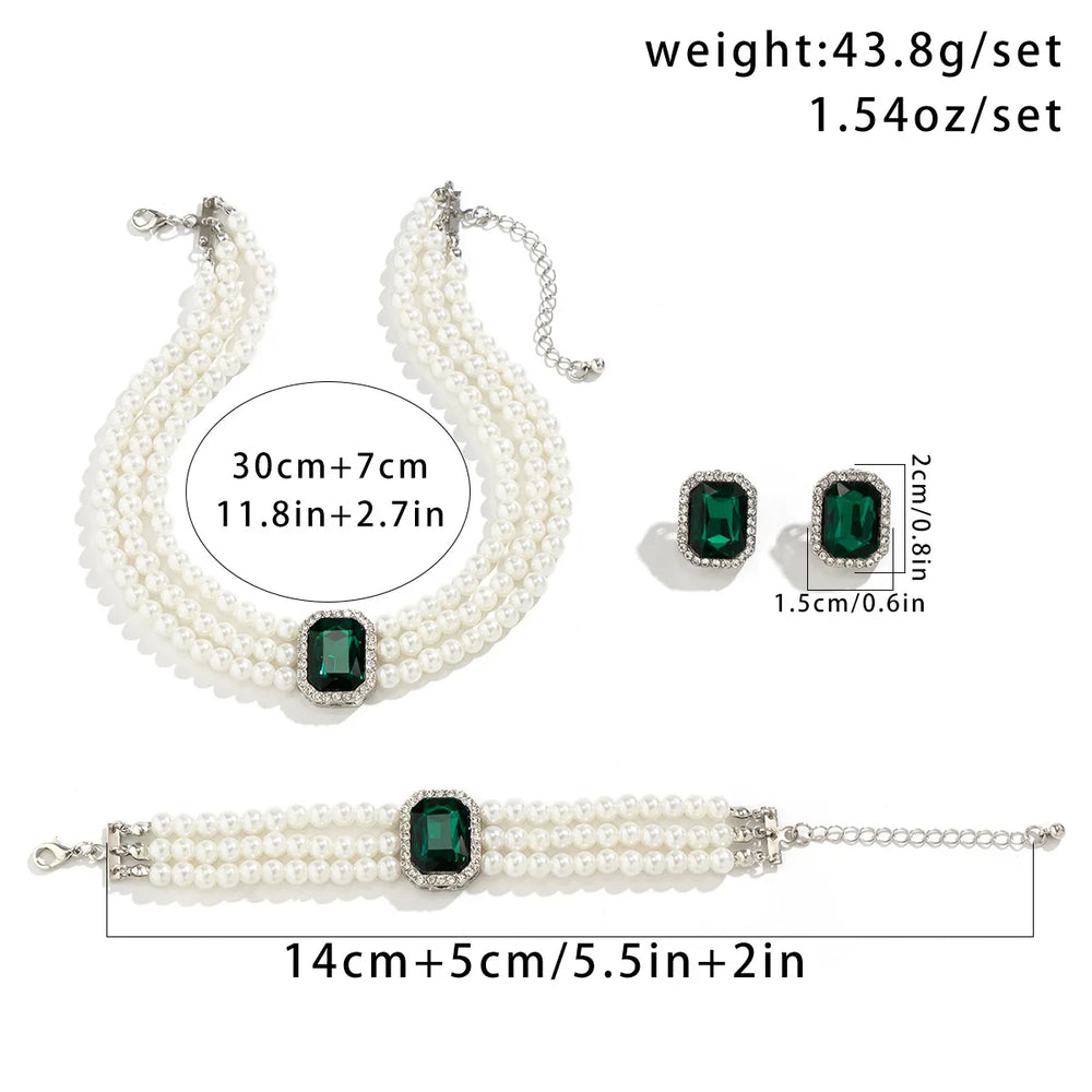 
                      
                        Pearl jewelry set with green gemstones including necklace, bracelet, and earrings on a white background.
                      
                    