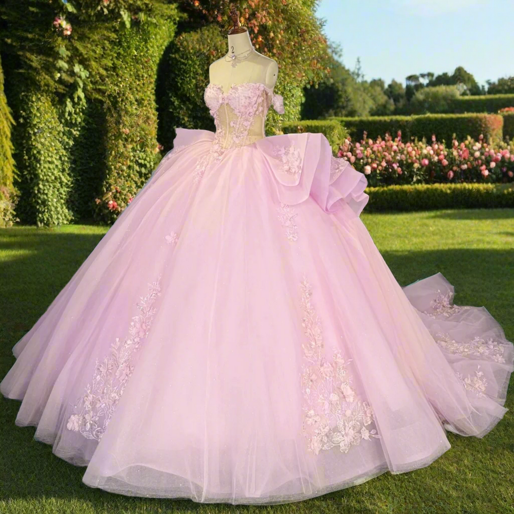 
                      
                        Pink evening gown with floral details on a mannequin in a room with other colorful dresses.
                      
                    