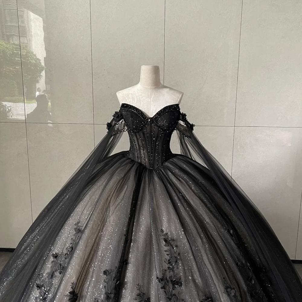 
                      
                        Black evening gown on a mannequin against a gray tiled wall
                      
                    