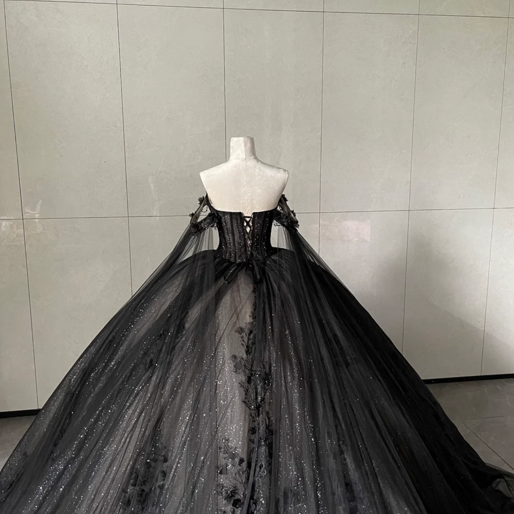 
                      
                        Black evening gown on a mannequin against a gray tiled wall
                      
                    