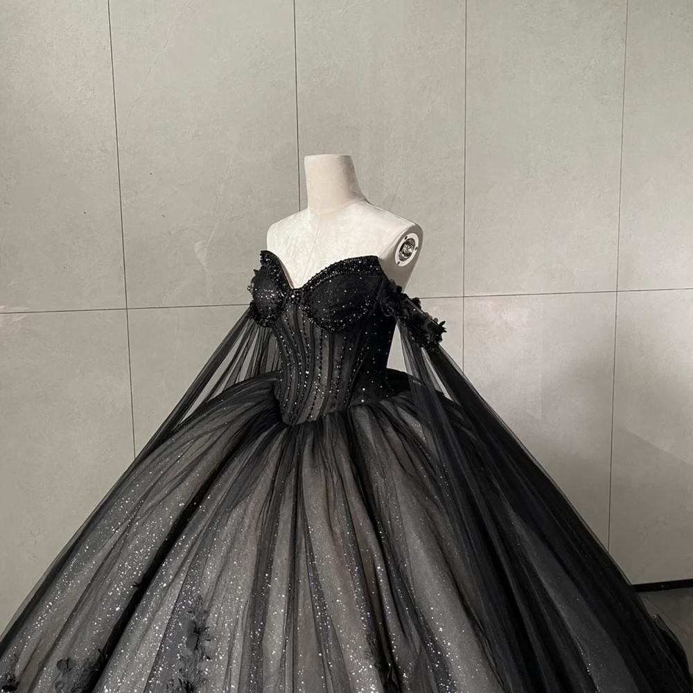 
                      
                        Black evening gown on a mannequin against a gray tiled wall
                      
                    