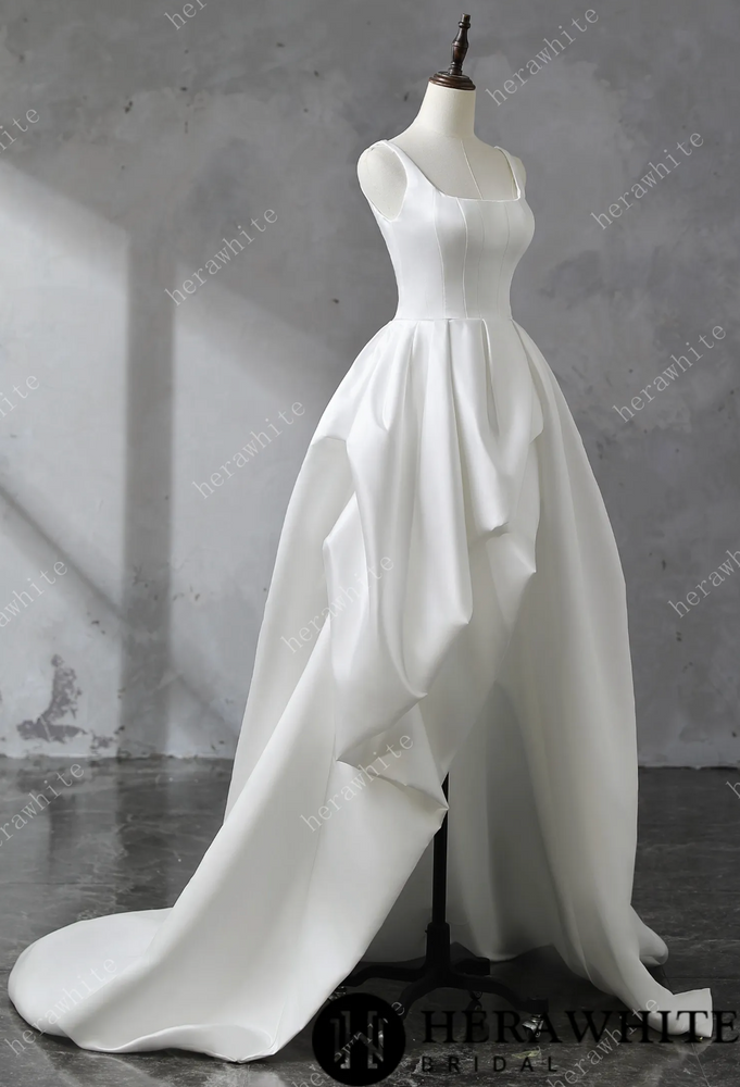 
                      
                        White satin wedding dress on a mannequin against a gray background
                      
                    