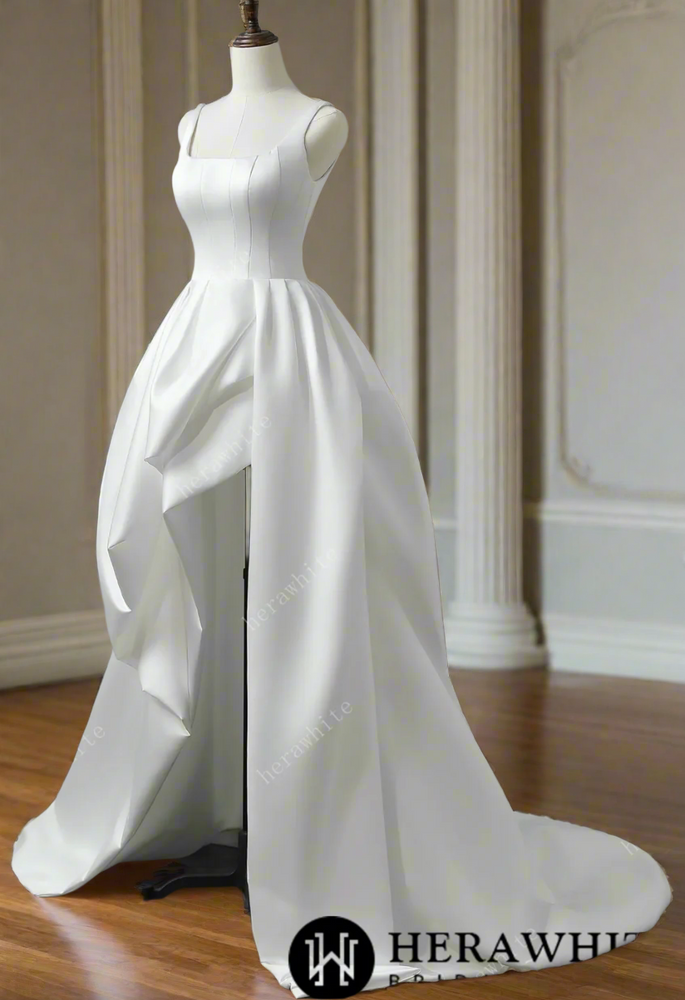 
                      
                        White satin wedding dress on a mannequin against a gray background
                      
                    