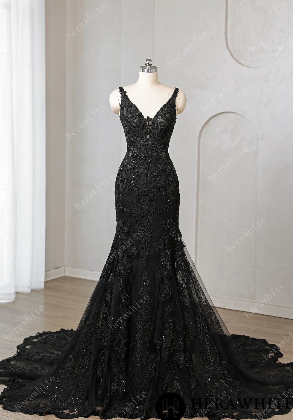 Black lace evening gown on a mannequin against a neutral background

