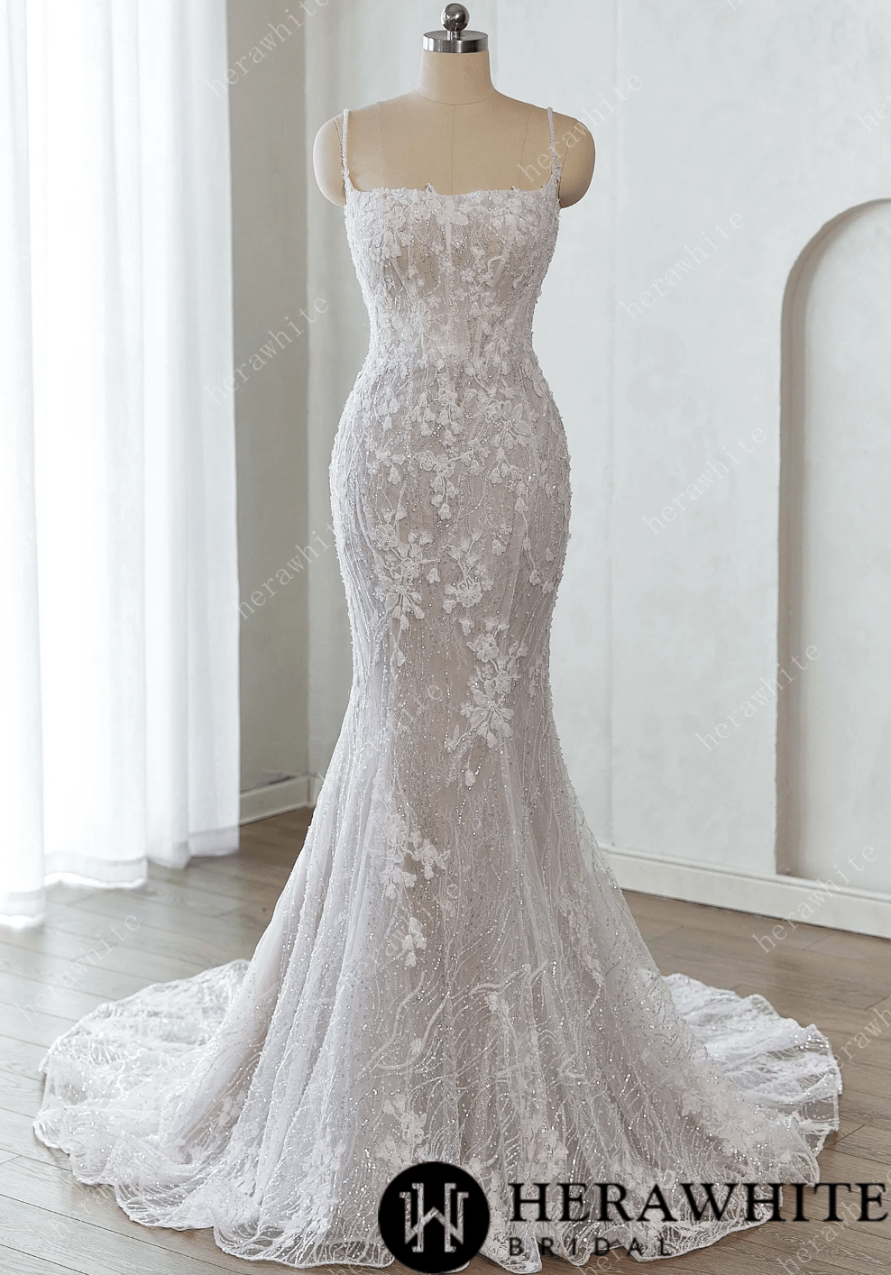 White lace wedding dress on a mannequin against a white background 