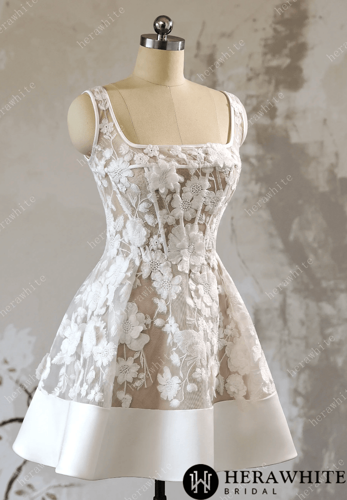 
                      
                        White lace dress on a mannequin against a textured gray background with 'Herawhite Bridal' branding.
                      
                    