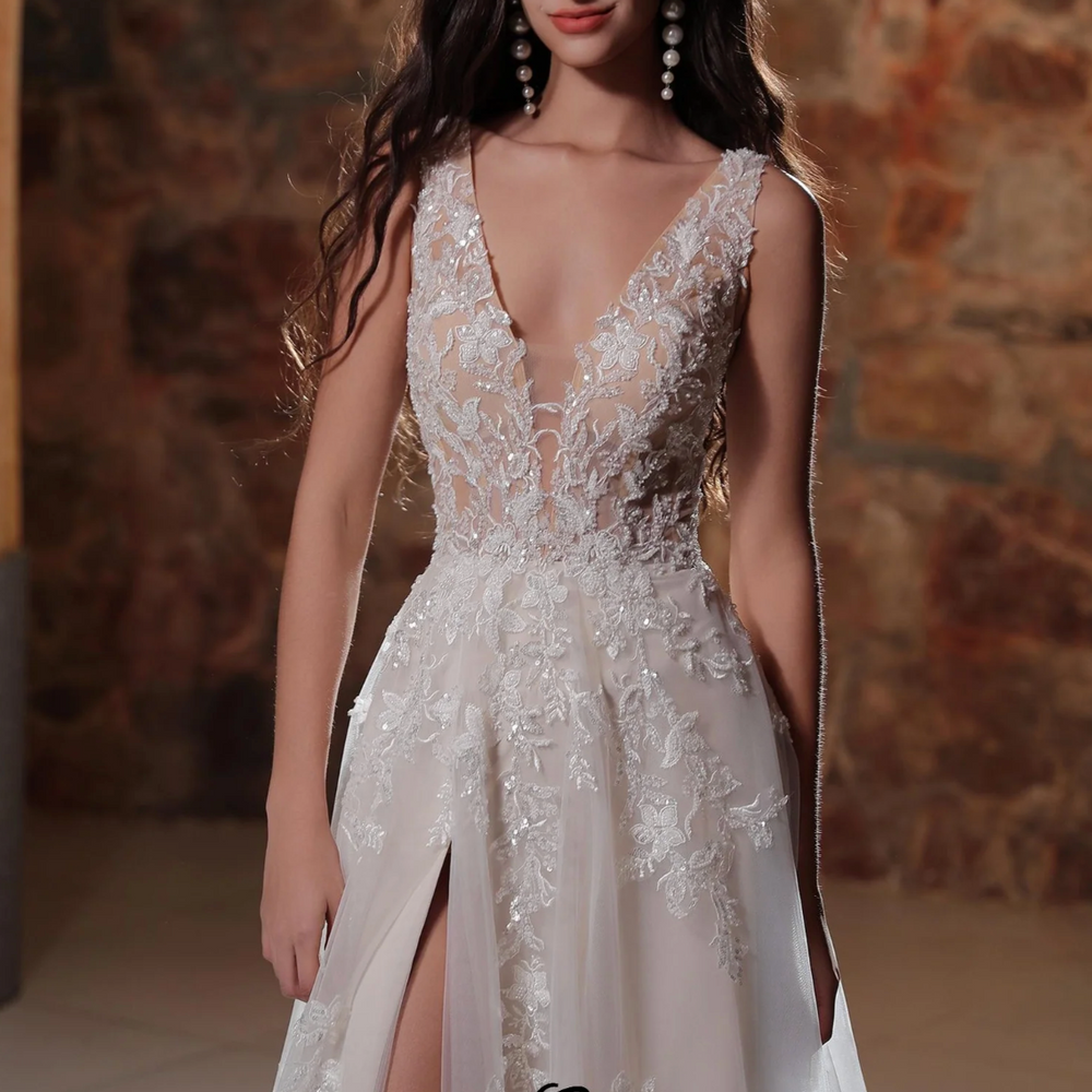 
                      
                        Plunging V-neckline A-line wedding dress with lace appliqués and thigh-high slit, perfect for brides.
                      
                    