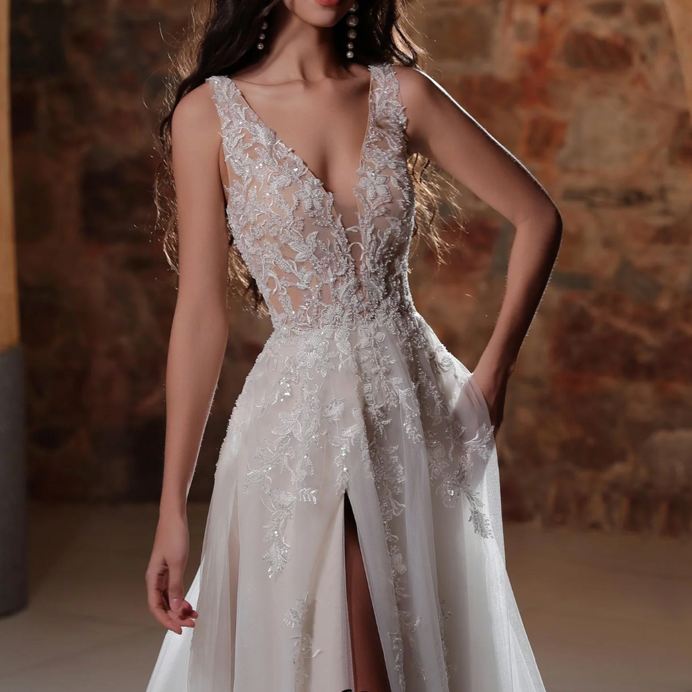 
                      
                        Plunging V-neckline A-line wedding dress with lace appliqués and thigh-high slit, perfect for elegant brides.
                      
                    