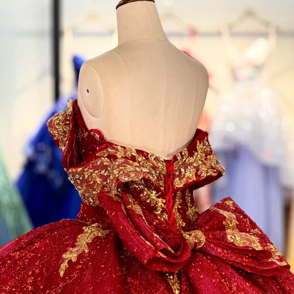 
                      
                        Red and gold dress on a mannequin with a blurred background
                      
                    