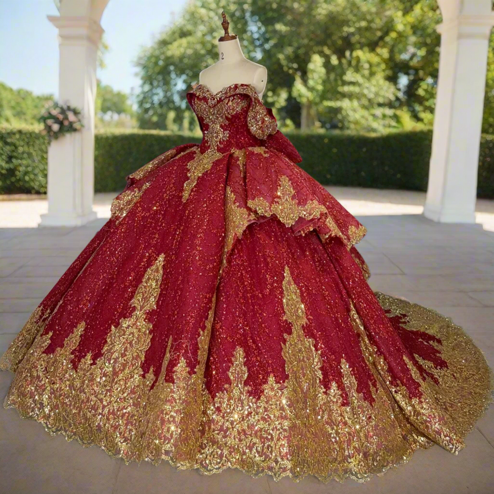 
                      
                        Red and gold ball gown on a mannequin in a room with other dresses.
                      
                    