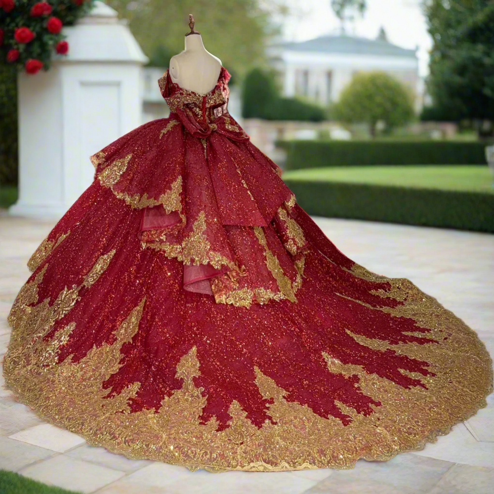 
                      
                        Red and gold ball gown on a mannequin in a room with other dresses.
                      
                    