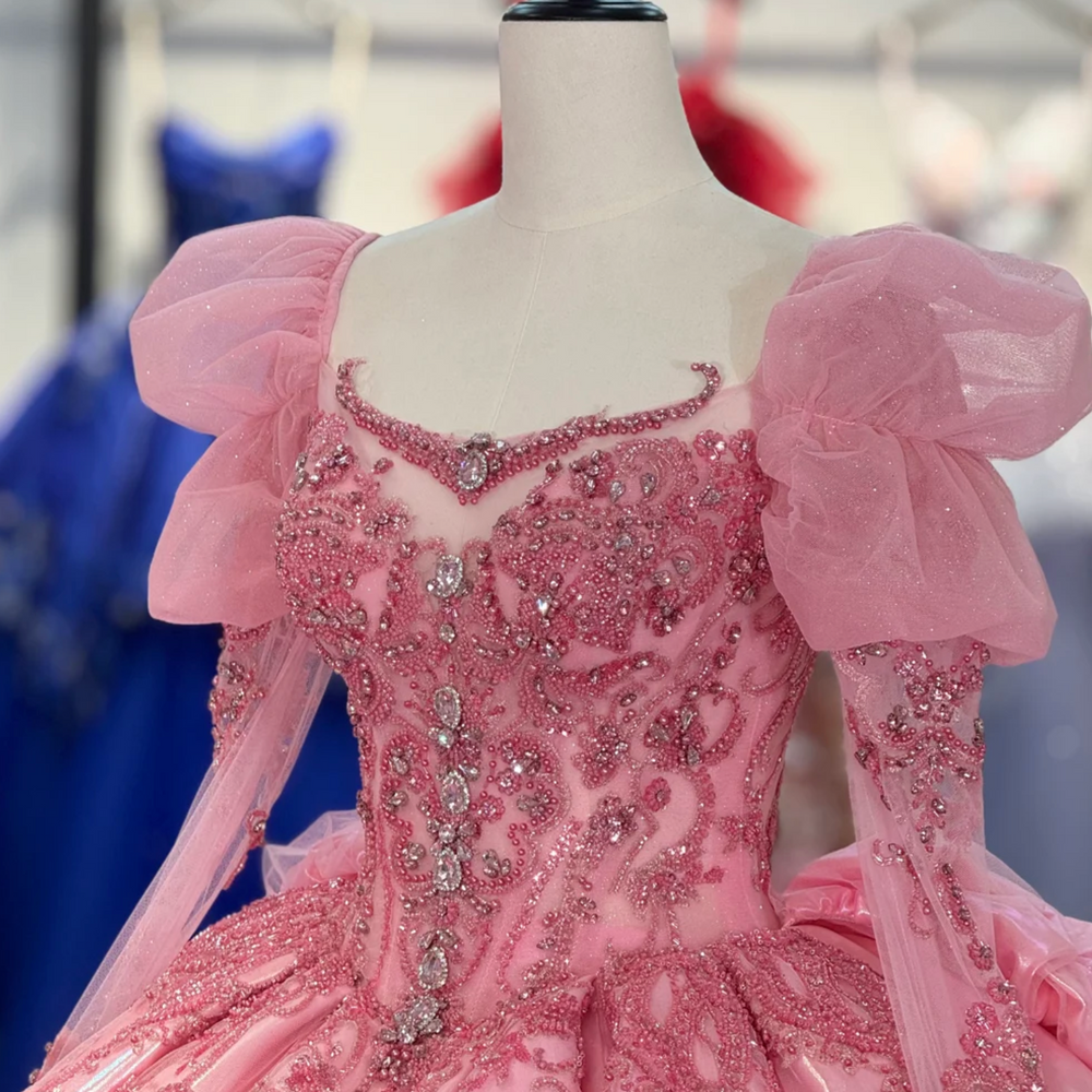 
                      
                        Pink beaded dress on a mannequin with a blurred background
                      
                    