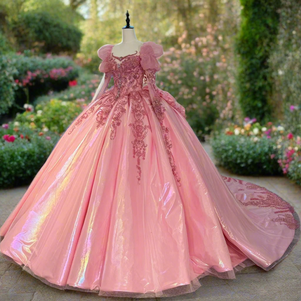 
                      
                        Pink ball gown on a mannequin in a room with other dresses.
                      
                    