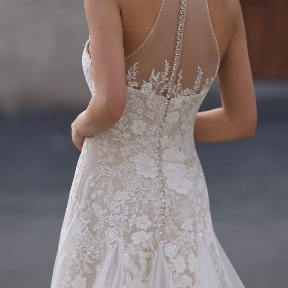 
                      
                        Lace wedding dress with intricate detailing, brand 'Ludyne Yuceld' visible.
                      
                    