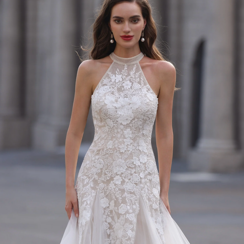 
                      
                        Woman wearing a white lace wedding dress with a blurred architectural background
                      
                    