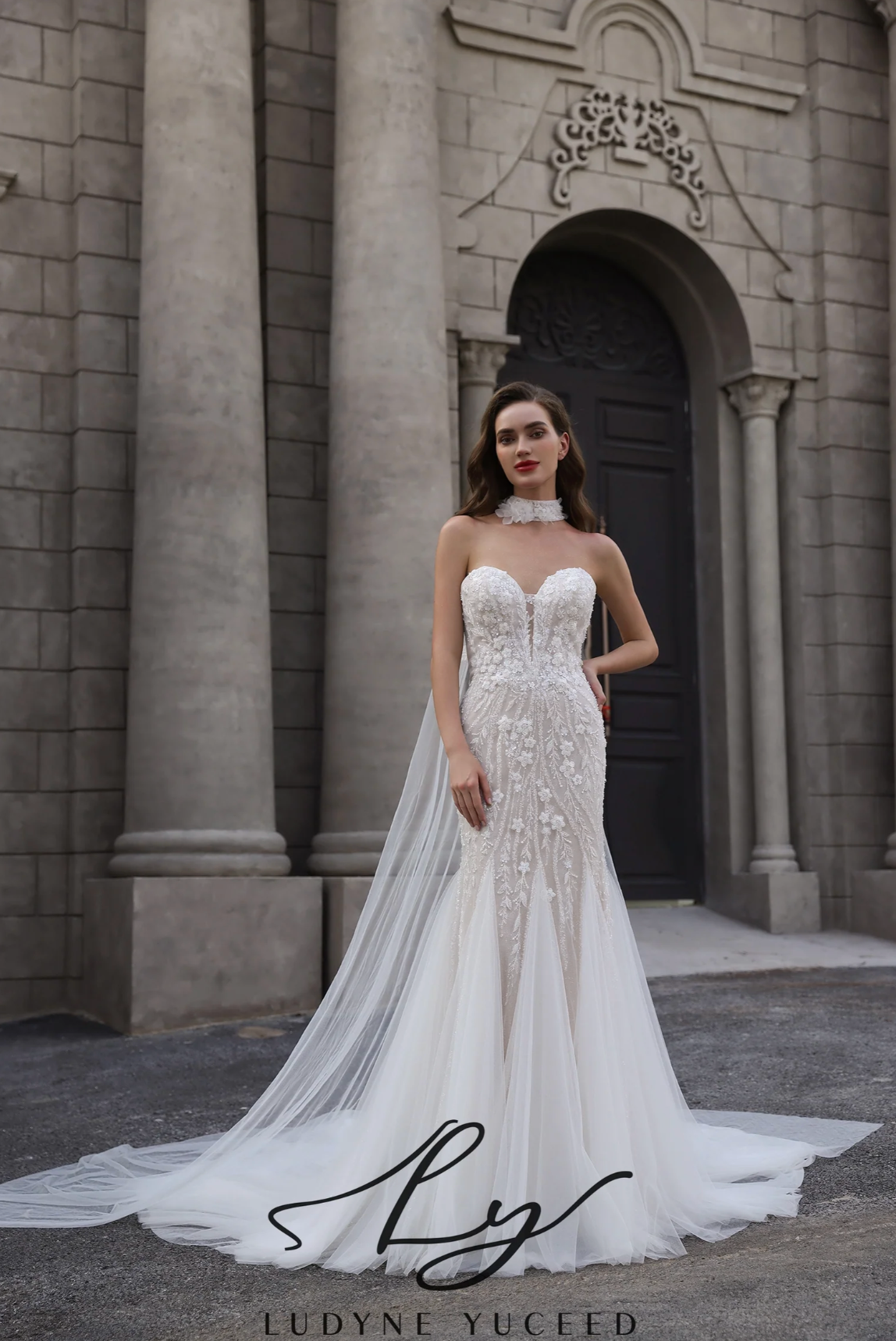 Woman in a white wedding dress standing in front of a stone building