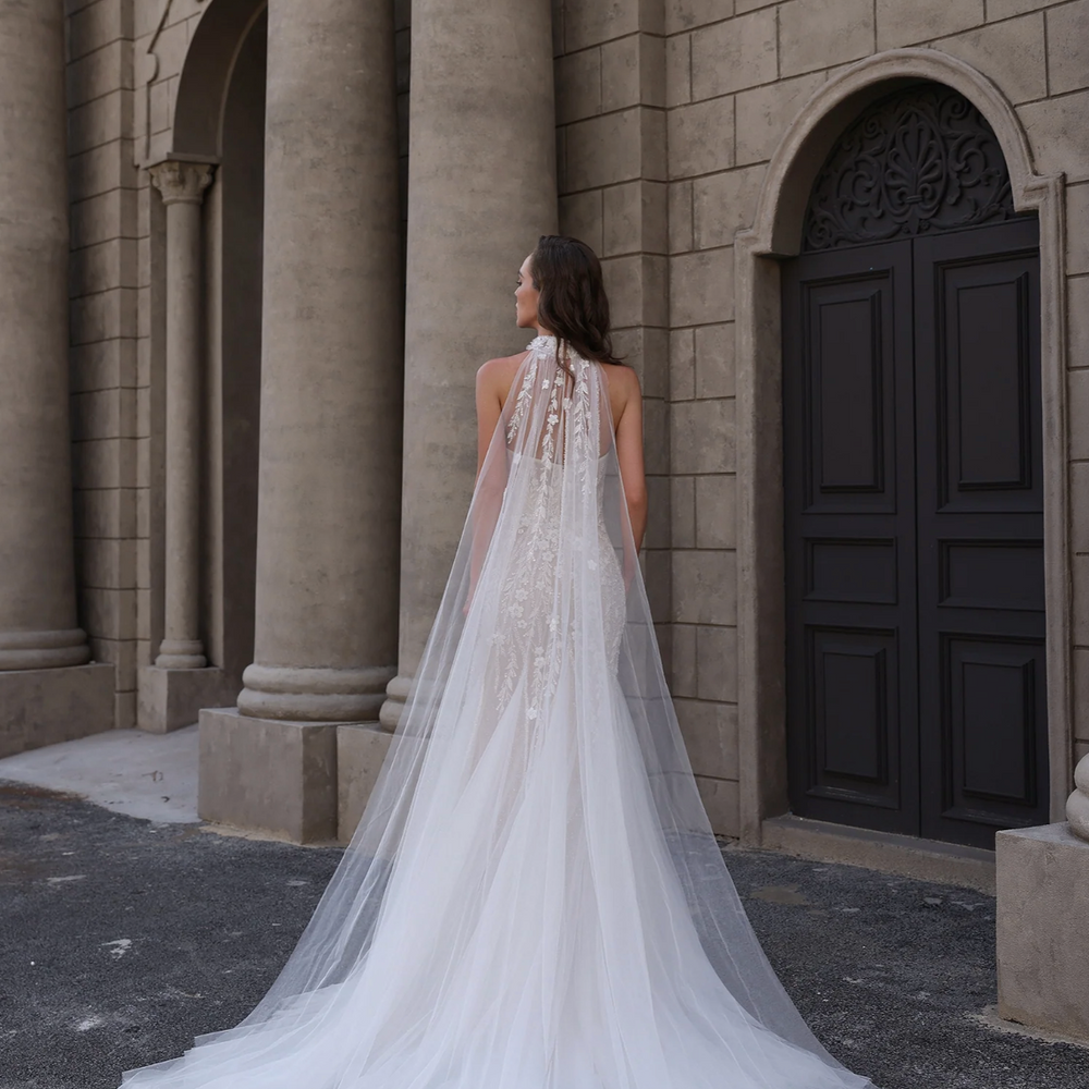 
                      
                        Woman in a white wedding dress standing in front of a classical building
                      
                    