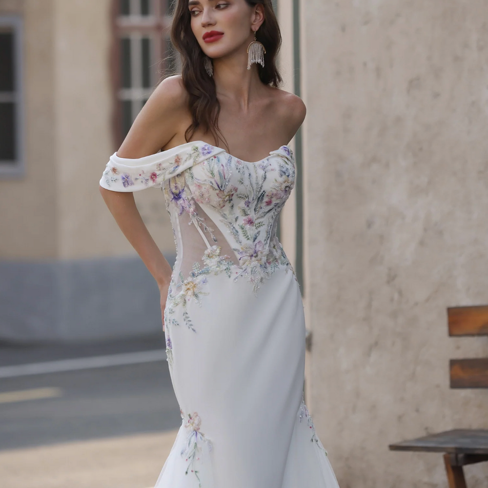 Woman wearing a white floral wedding dress in an outdoor setting