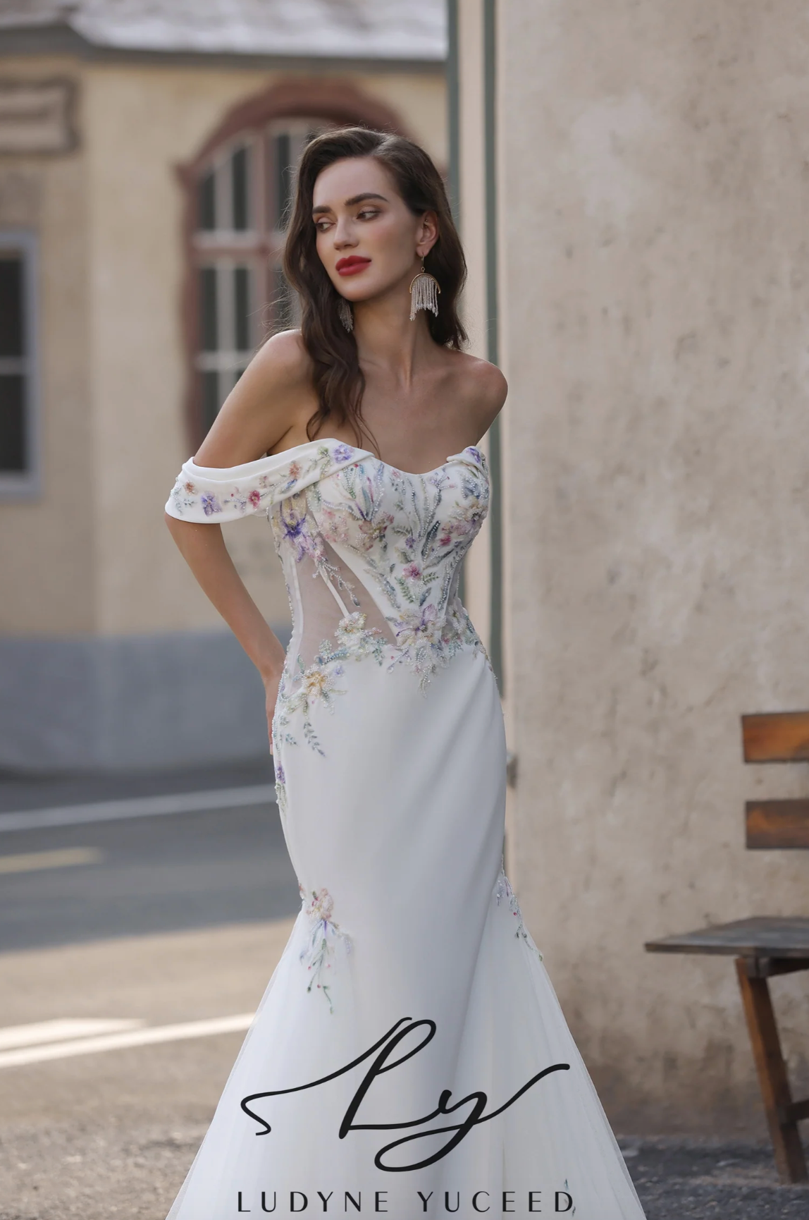 Woman wearing a white floral wedding dress in an outdoor setting