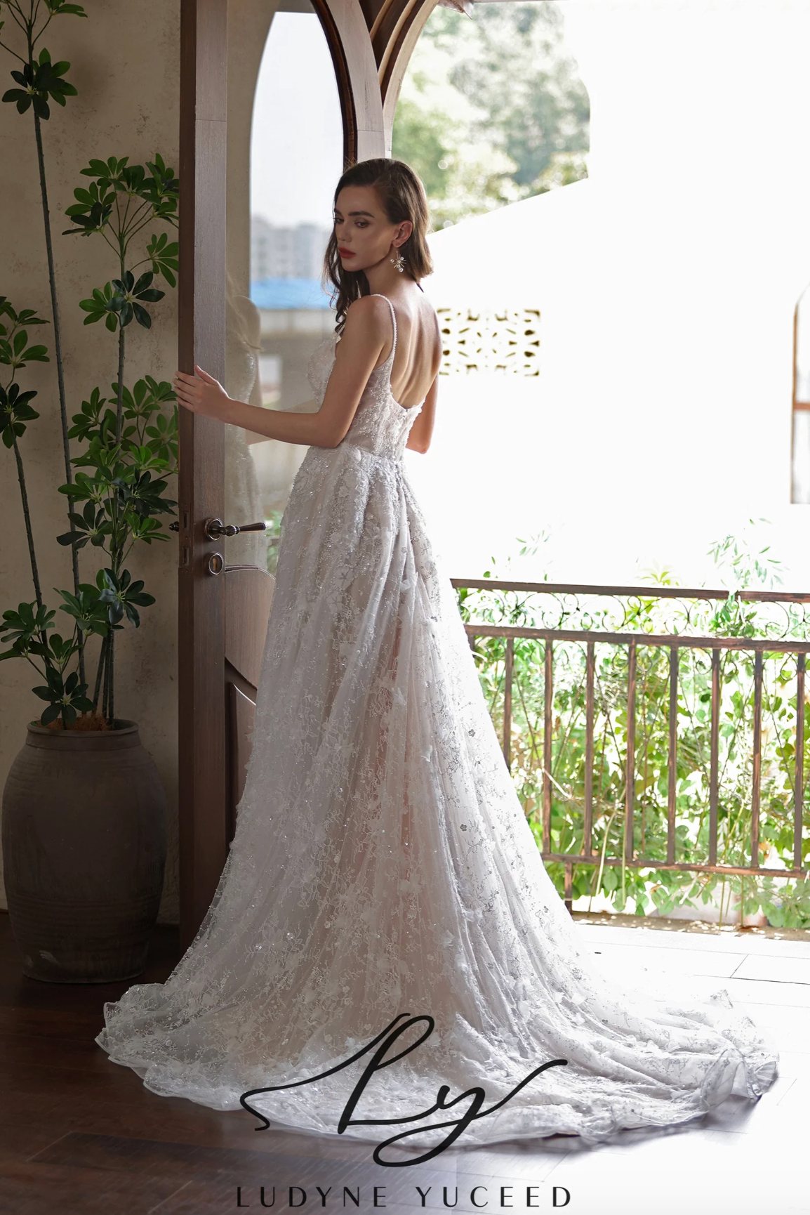 Elegant bride in romantic floral lace wedding gown with a train, showcasing a modern and ethereal style.