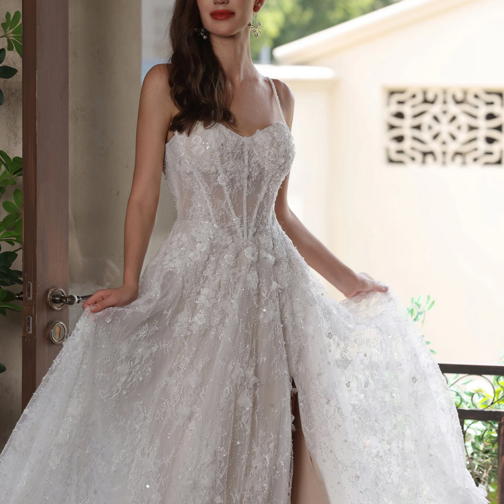 
                      
                        Romantic floral lace wedding gown with high slit, spaghetti straps, and sweetheart neckline, showcasing modern bridal elegance.
                      
                    