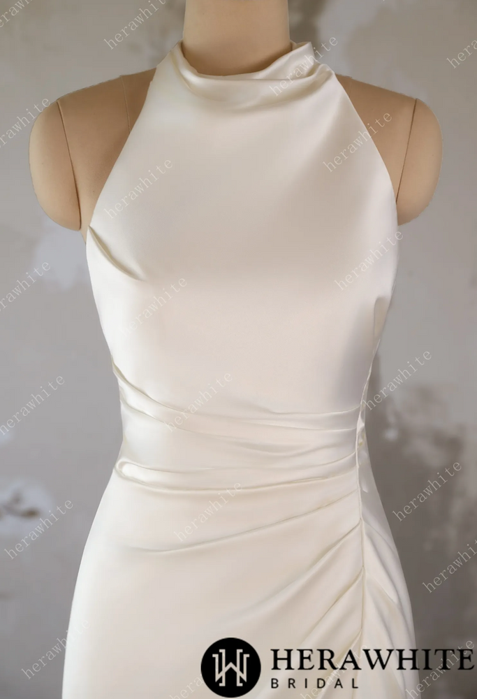 
                      
                        White wedding dress on a mannequin against a textured wall background
                      
                    