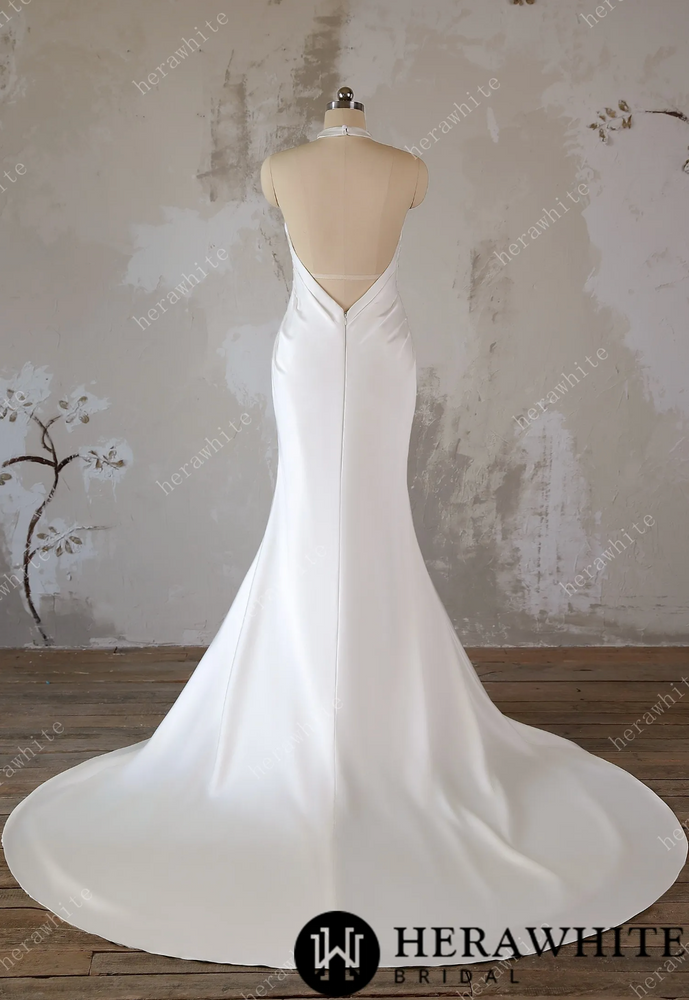 
                      
                        White wedding dress on a mannequin against a textured wall background
                      
                    