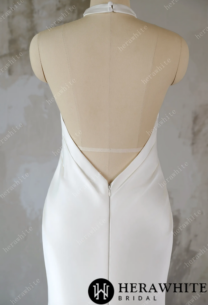 
                      
                        White wedding dress on a mannequin against a textured wall background
                      
                    