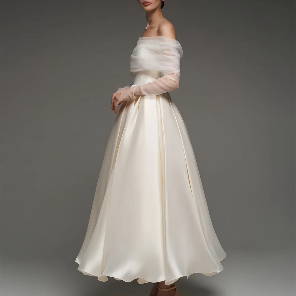 Woman wearing a white off-shoulder dress with a plain background