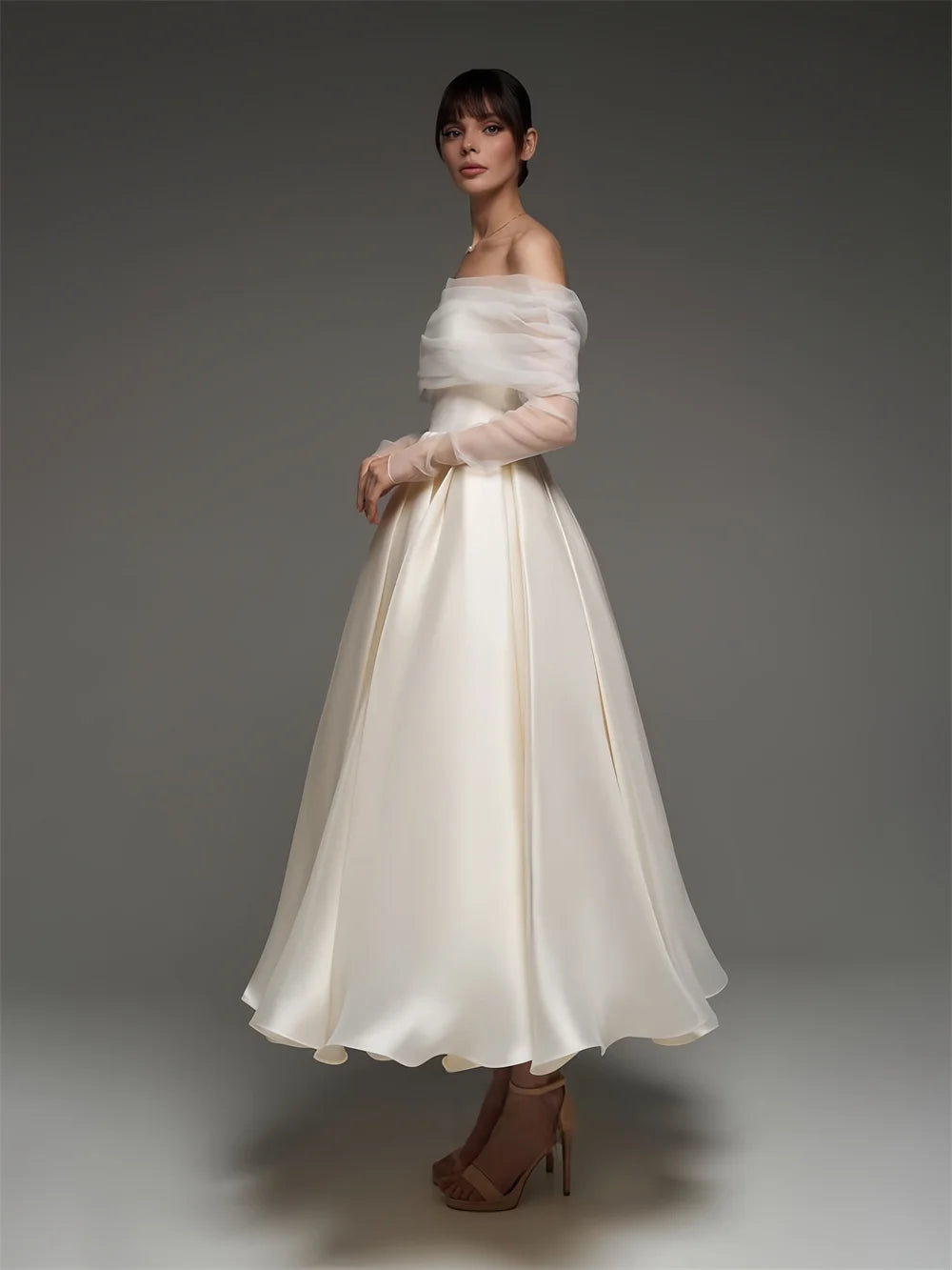 Woman wearing a white off-shoulder dress with a plain background