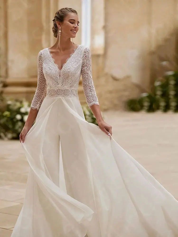 
                      
                        Woman wearing a white wedding dress with lace detailing in an outdoor setting.
                      
                    