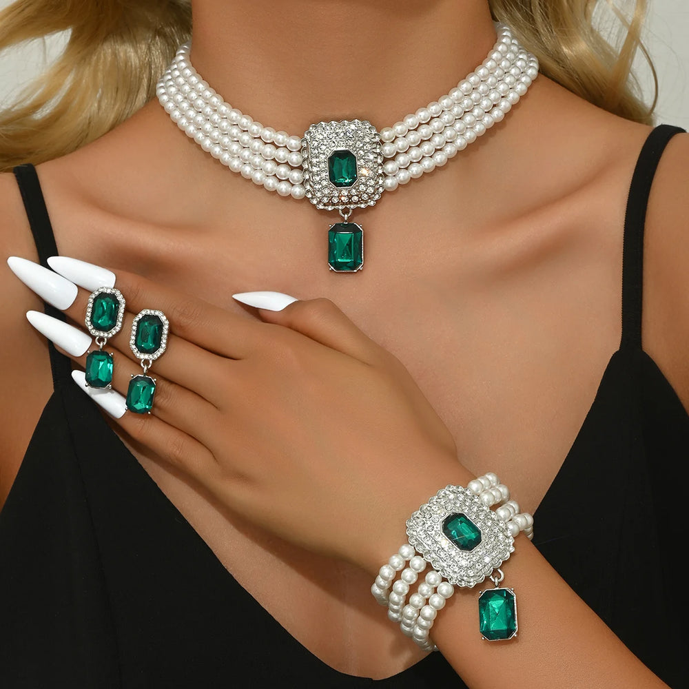 
                      
                        Jewelry set with pearls and emeralds on a model wearing a black top.
                      
                    